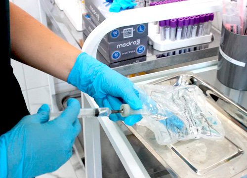 Врач подготавливает капельницу